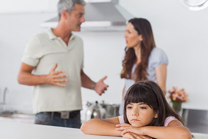 Parents arguing behind distraught daughter